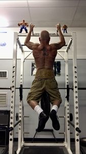 Doug Holland performing weighted chin ups.